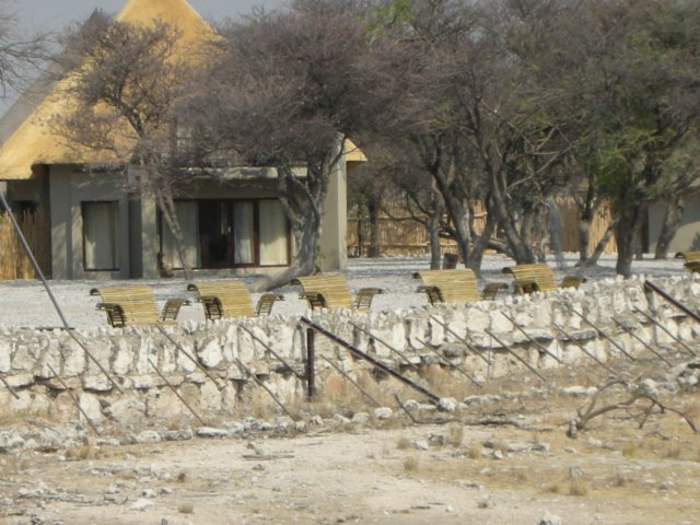 okaukuejorestcampwithitsbenchesforviewingthewaterholeethoshanationalparknamibia.jpg